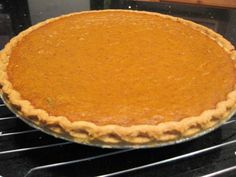 a pumpkin pie sitting on top of an oven rack in the middle of it's baking process