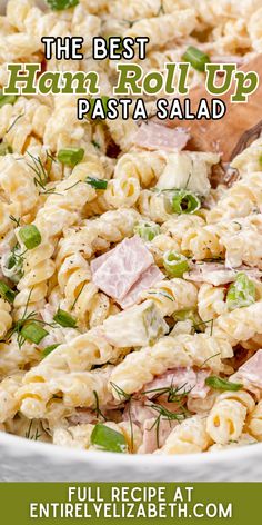 the best ham roll up pasta salad is in a white bowl with a wooden spoon