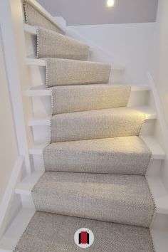 a carpeted stair case with a red and white button on the bottom floor next to it