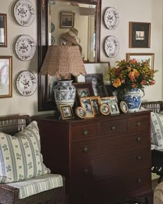 a living room filled with lots of furniture and pictures on the wall next to a dresser