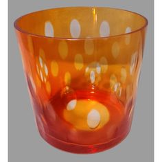 an orange glass with white dots on it