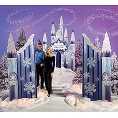 a man and woman standing in front of a castle with snowflakes on it