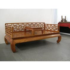 a wooden coffee table with two benches on it and a red dresser in the background