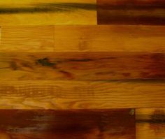 a close up view of wood flooring that has been stained yellow and brown with black streaks