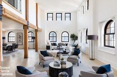 a large living room with high ceilings and lots of windows