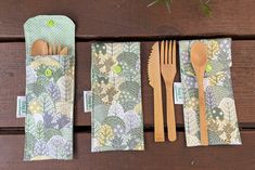 wooden utensils and spoons are lined up on a table with napkins