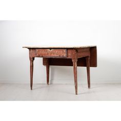 an old wooden desk sitting on top of a white floor