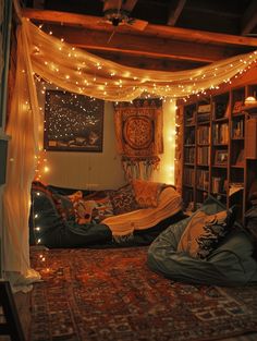 a living room filled with lots of furniture and lights hanging from the ceiling above it