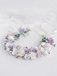 a white and purple flower crown on a bed