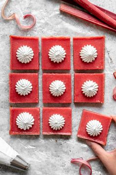 some red squares with white decorations on top of them next to scissors and other crafting supplies