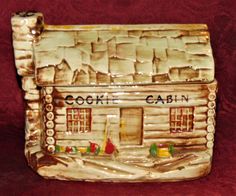 a ceramic cookie cabin is sitting on a red surface with the words cookie cabin painted on it