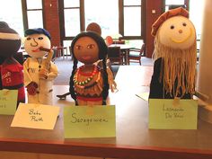 three dolls are sitting on the table with notes attached to them