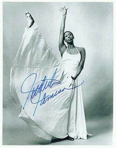 an autographed photo of a woman in a white dress with her arms up