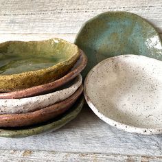 a stack of ceramic bowls sitting on top of a wooden table