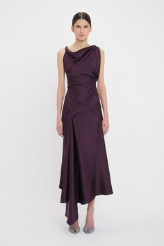 A personal favourite of Victoria’s, the Asymmetric Draped Midi Dress in a regal shade of Fig is crafted from a body-skimming crepe back satin cut into a fit-and-flare silhouette. Twisted shoulder straps bring a tactile point of difference, while an off-centre drape at the front of the skirt has an elongating effect. A V-shaped seam at the back of the waist and topstitch detailing add unique talking points. Styled with the Open Toe Cage Sandal & the 202 Bag Asymmetrical Pre-draped Cocktail Midi Dress, Pre-draped Midi Dress With Asymmetrical Hem, Pre-draped Midi Dress With Asymmetrical Hem And Draped Sleeves, Luxury Midi Dress With Asymmetrical Neckline, Pre-draped, Luxury Asymmetrical Bias-cut Satin Dress, Skirt Draping, Draped Midi Dresses, Mob Dresses, Asymmetric Hem