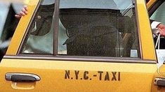 a taxi cab with the driver's seat up and his hand on the door handle