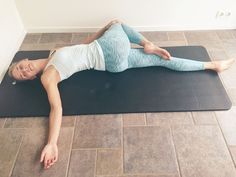 a woman laying on top of a yoga mat