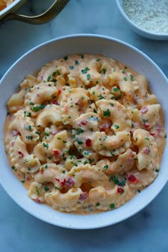 a white bowl filled with macaroni and cheese on top of a blue table