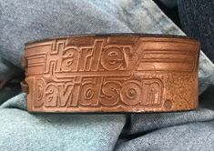 "Add a classy Harley Davidson look to your wrist! This bracelet has Harley Davidson embossed on it with a nickel concho on one side of the leather bracelet. It has soft leather deerskin ties for closure at the wrist, and is adjustable by these. It measures approximately 1.25\" wide by 8\" in length not including the ties. Made from repurposed but licensed materials. You can see the trademark in the pics - HD. Thank you for looking!" Vintage Stamped Leather Cuff Bracelet, Stamped Leather Vintage Cuff Bracelet, Adjustable Western Leather Bracelet, Adjustable Stamped Leather Bracelet, Vintage Leather Bracelet With Engraving, Vintage Engraved Leather Bracelets, Vintage Leather Engraved Bracelet, Adjustable Leather Bracelet With Stamp Details, Engraved Brown Leather Bracelet