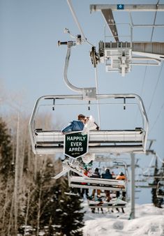 a person riding a ski lift on top of snow covered ground