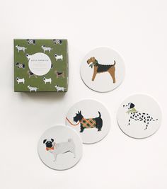 four coasters with dogs on them sitting next to a green box and white background