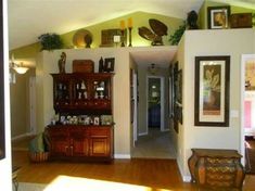 a living room filled with furniture and pictures on the wall