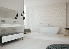 a modern bathroom with white walls and flooring, including a freestanding bathtub