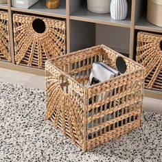 two wicker baskets sitting on top of a rug next to a book shelf filled with books