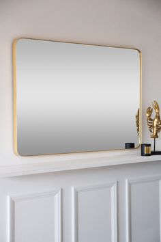 a mirror sitting on top of a white mantle