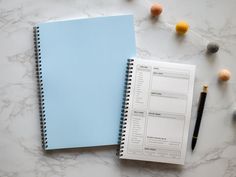 a note book and pen on a marble surface