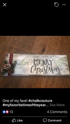 a wooden sign that says merry christmas and is sitting on the floor next to a red ribbon