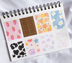 an open notebook with various stickers and patterns on the pages, including strawberries