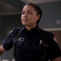 a woman police officer standing in front of a counter with her hand on her hip