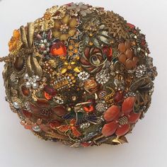 a close up of a brooch on a white surface with beads and other items