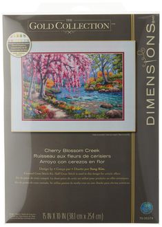 the cross stitch kit is shown with an image of a river and trees in bloom