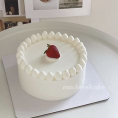 a white cake with a strawberry on top