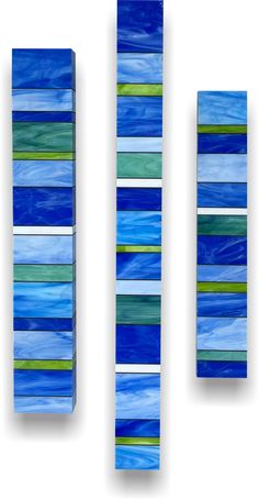 three pieces of art made out of blue and green paper with horizontal stripes on them