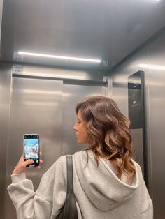 a woman taking a selfie in an elevator