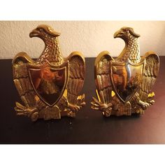 two golden eagle bookends sitting on top of a table