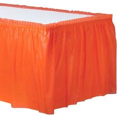 an orange plastic table skirt with white top