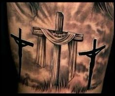 a man's back with three crosses on it and clouds in the sky behind him