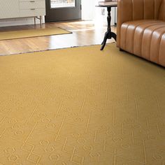 a living room with a brown leather couch and yellow carpet