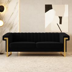 a black and gold couch sitting in front of a wall with paintings on the walls