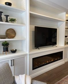 a living room filled with furniture and a flat screen tv mounted on a wall above a fire place