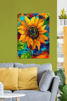 a painting of a sunflower on a wall in a living room with green walls