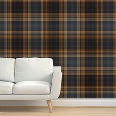 a couch sitting in front of a wall with a plaid pattern on it's side