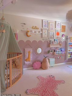 a child's room with pink walls and pictures on the wall