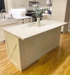 a white kitchen with an island in the middle