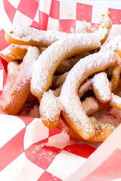 powdered sugar covered pretzels in a basket on a checkered tablecloth