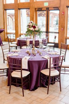 the tables are set with purple linens and white tablecloths for an elegant wedding reception